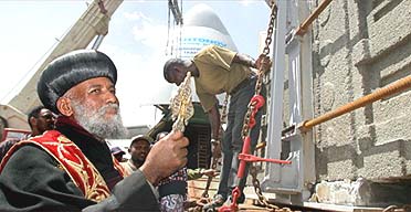 A priest from the Ethiopian Orthodox church blesses a piece of the ancient Axum obelisk as it arrives in Axum 68 years after it was looted by Italian troops