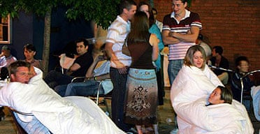 Hotel guests take cover under blankets outside their hotel after they were evacuated following a security alert in Birmingham city centre. 