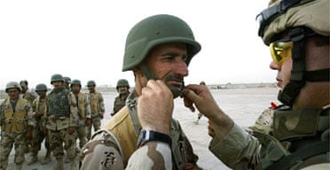 A US adviser fixes the helmet strap of an Iraqi soldier on the outskirts of the city of Baquba. Photograph: Ghaith Abdul-Ahad/Getty