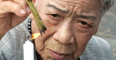 A Japanese woman burns incense to comfort the souls of atomic bomb victims in Nagasaki. Photograph: Yuriko Nakao/Reuters