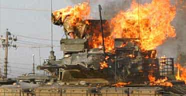 A British soldier prepares to jump from a burning tank which was set ablaze after a shooting incident in the southern Iraqi city of Basra