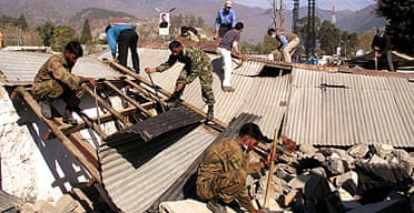 Pakistani soldiers take part in the reconstruction of houses destroyed by the October earthquake in Muzaffarabad, the capital of Pakistani Kashmir