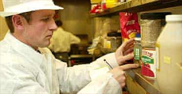 An environmental health officer inspects the kitchen of a restaurant