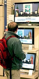 A man watches television screens as ETA terrorists declare a permanent ceasefire