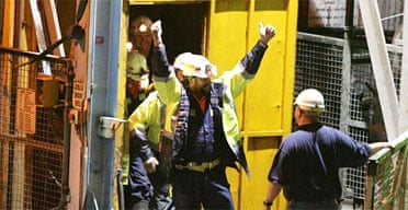 Tasmanian miners Todd Russell and Brant Webb wave as they emerge from the mine lift. Photograph: Ian Waldie/Getty