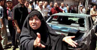 A woman gestures as soldiers secure the scene after two roadside bombs exploded in Baghdad. Photograph: Karim Kadim/AP