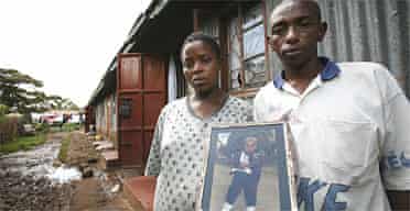 Francis Mbugua and his partner Lucy are holding a picture of their son Christopher, kidnapped six years ago at the age of two. Photograph: David Levene