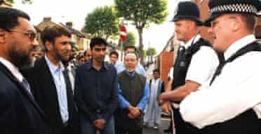 Muhammad Abdul Bari ( 2nd left), the newly elected secretary general of the Muslim Council of Britain, talks to police officers in Forest Gate, east London. Photograph: John Stillwell/PA 