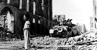 A British tank looms behind an Egyptian boy amid the rubble of Port Said during the Suez crisis. Photograph: Hulton-Deutsch Collection/Corbis