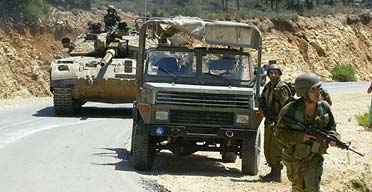 Israeli troops roll on a road near the Israeli-Lebanese border