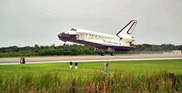 The space shuttle Discovery comes into land