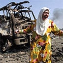 A Lebanese woman cries in front of a destroyed truck in southern Beirut