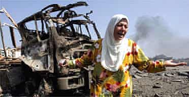 A Lebanese woman cries in front of a destroyed truck in southern Beirut