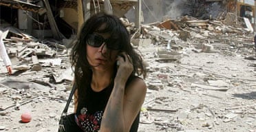 A Lebanese woman talks on her phone as she walks through a destroyed street in the southern suburbs of Beirut, Lebanon, Saturday, July 22, 2006. Photograph: Hussein Malla/AP