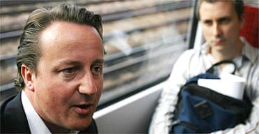 David Cameron speaks to commuters on a train to Waterloo, London