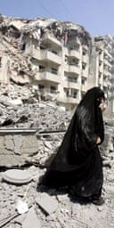 A Lebanese woman makes her way through rubble in southern Beirut.