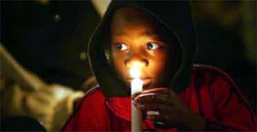 A child attends a vigil for Aids victims in Ngwenya