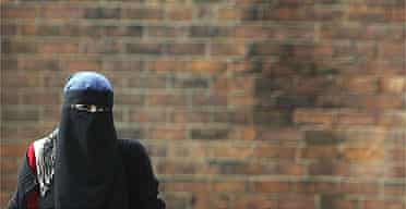 A Muslim woman wearing a Niqab walks in Blackburn, the constituency of MP Jack Straw