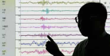 A member of staff at Japan's meteorological agency shows the point on a seismograph where North Koreas nuclear test was registered