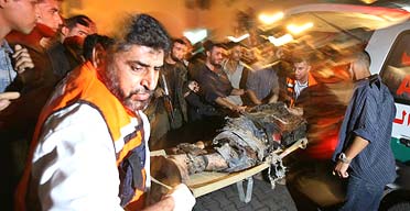 Palestinian doctors wheel the body of a militant killed during an Israeli operation in the Gaza Strip