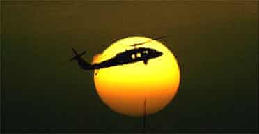 A US military helicopter flies over the heavily fortified Green Zone that houses the US Embassy and Iraqi government buildings at sunset. 