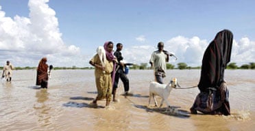 Displaced people walk through rising floodwaters in Dadaab, Kenya