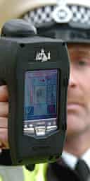 A police officer holds a portable finger print analyser at the launch of the device. 