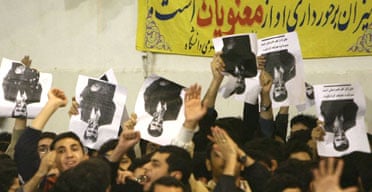 Iranian reformist students hold portraits of the country's president, Mahmoud Ahmadinejad, upside down in protest during his visit a Tehran university