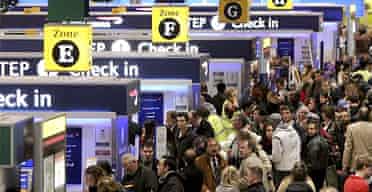 Passengers queue to check in at Heathrow airport