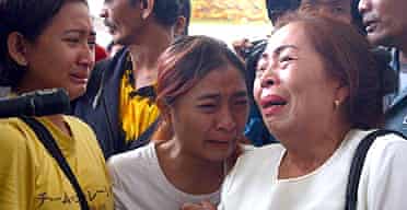 Distraught relatives of passengers await news from the scene of the Boeing 737 crash on Sulawesi island