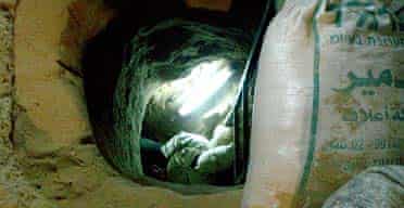 A smuggler enters a tunnel that runs from Gaza to Egypt
