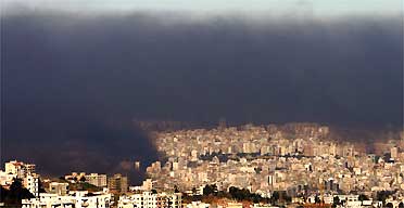 Smoke from burning tyres and debris hangs over Beirut as thousands of demonstrators enforcing a general strike aimed at toppling the government brought much of Lebanon to a standstill. Photograph: Hussein Malla/AP  
