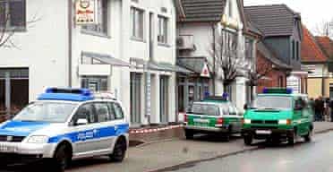 Police officers secure the area in front of the Chinese restaurant in Sittensen where six bodies were found shot dead 