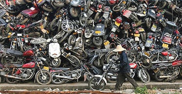 A worker pushes parts of a motorcycle at a scrapyard in Guangzhou, southern China.