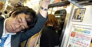 A Japanese commuter nods off during his journey on the Tokyo underground