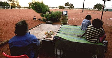 Aborigines watch television at an outstation in the Utopia community, Australia
