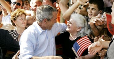 George Bush greets a women holding a US flag during a visit to Fushe Kruje in Albania