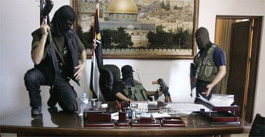 Palestinian militants from Hamas stand at the desk of Palestinian President Mahmoud Abbas inside Abbas' personal office after it was taken over by Hamas in fighting in Gaza City. Photograph: Hatem Moussa/AP.