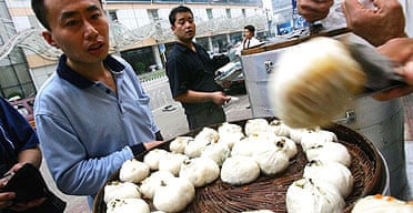 Customers buy steamed buns at a roadside stall in Beijing