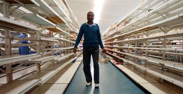 A Zimbabwean shopper walks through the empty shelves of a store in Harare