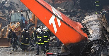 Firefighters remove human remains from the scene of Brazil's worst air crash at Congonhas airport in Sao Paulo