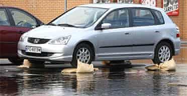 A car parked on sandbags to avoid flood damage in Botley, near Oxford