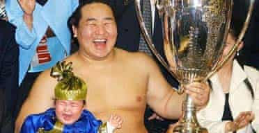 Sumo champion Asashoryu celebrates winning the Emperor's Cup with his daughter in 2004