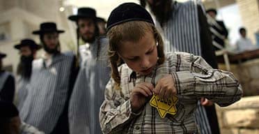 A young member of Neturei Karta pins on a yellow star, resembling those forced on Jews during the Holocaust