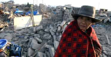 A woman walks through rubble in Ica, south of Lima. Photograph: Carlos Lezama/AFP-Getty