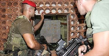 Italian paramilitary police officers inspect a secret bunker in a house in San Luca