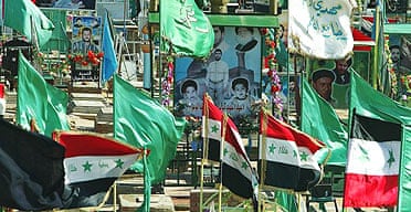 Flags fly at a cemetery in Najaf, the day after more than 200 people were killed in a series of coordinated attacks in the city
