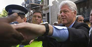 Bill Clinton shakes hands with people in the crowd as he leaves Waterstones in Regent Street, London where he was signing copies of his new book, How Each of Us Can Change the World.