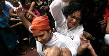 Members of a Nicaraguan feminist group fight with Catholic faithful during a mass inside a cathedral in Managua