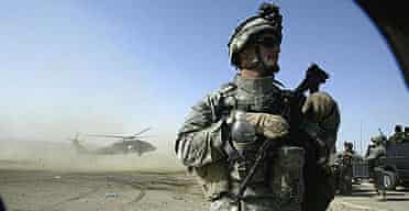 A US soldier stands guard as a Blackhawk helicopter lands in Kerbala, Iraq.